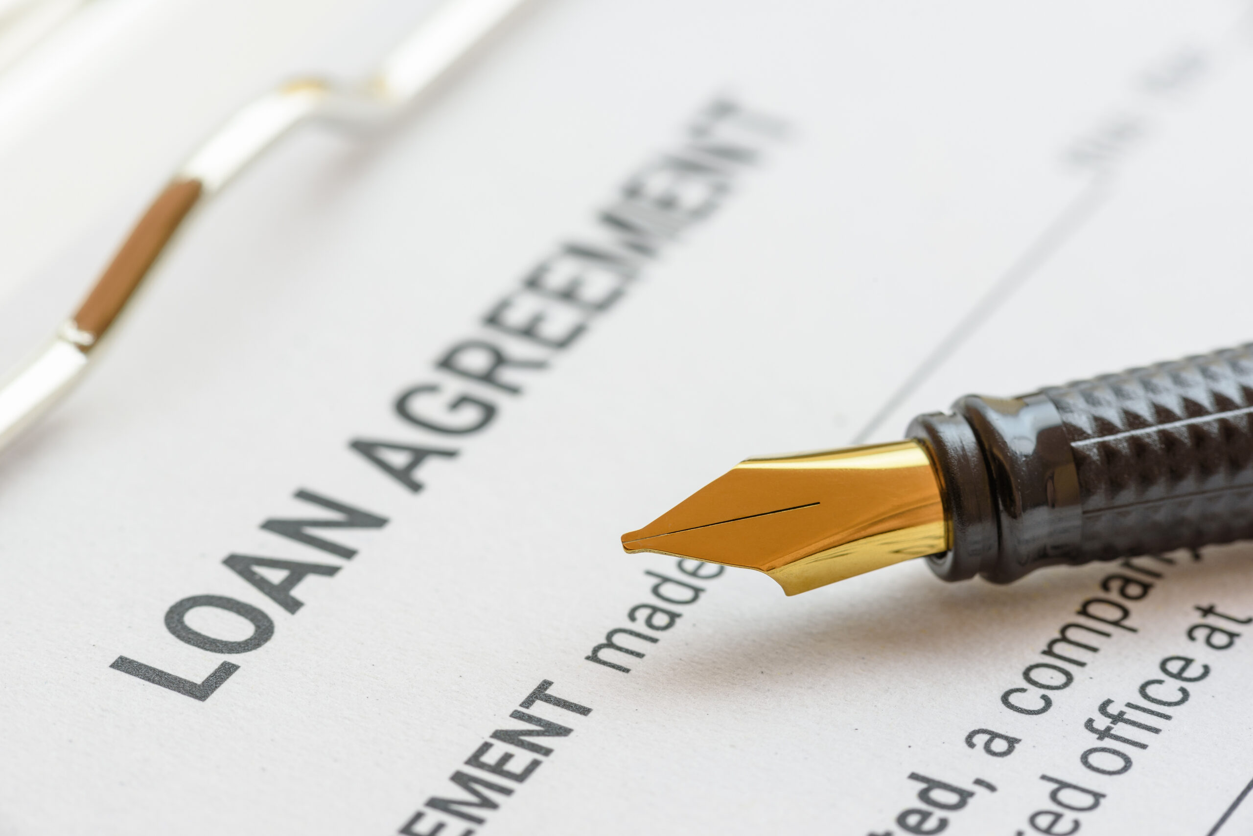 Loan agreement or legal document concept : Fountain pen on a loan agreement paper form. Loan agreement is a contract between a borrower and a lender, a compilation of various mutual promises.