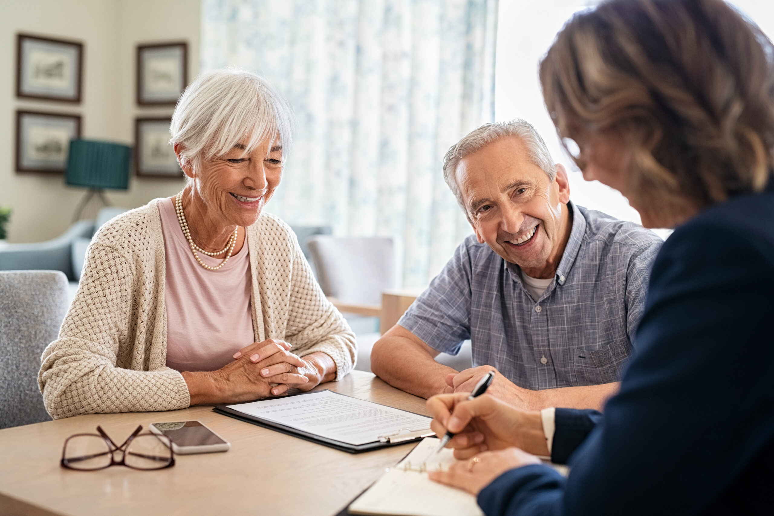 Senior couple with financial advisor at home.